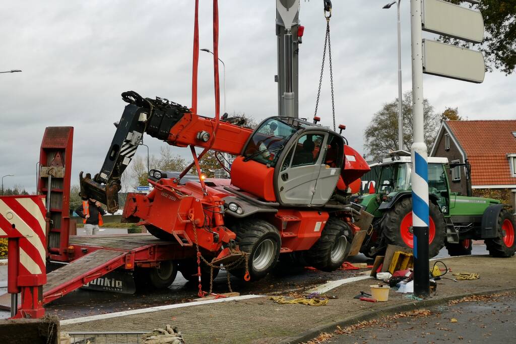 Grote aanhanger met verreiker op z'n kant op rotonde