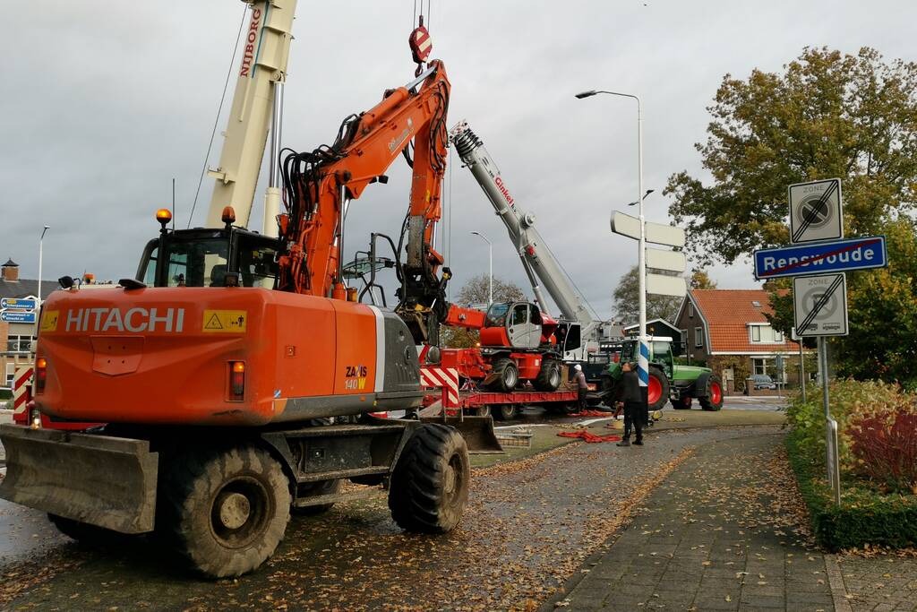 Grote aanhanger met verreiker op z'n kant op rotonde