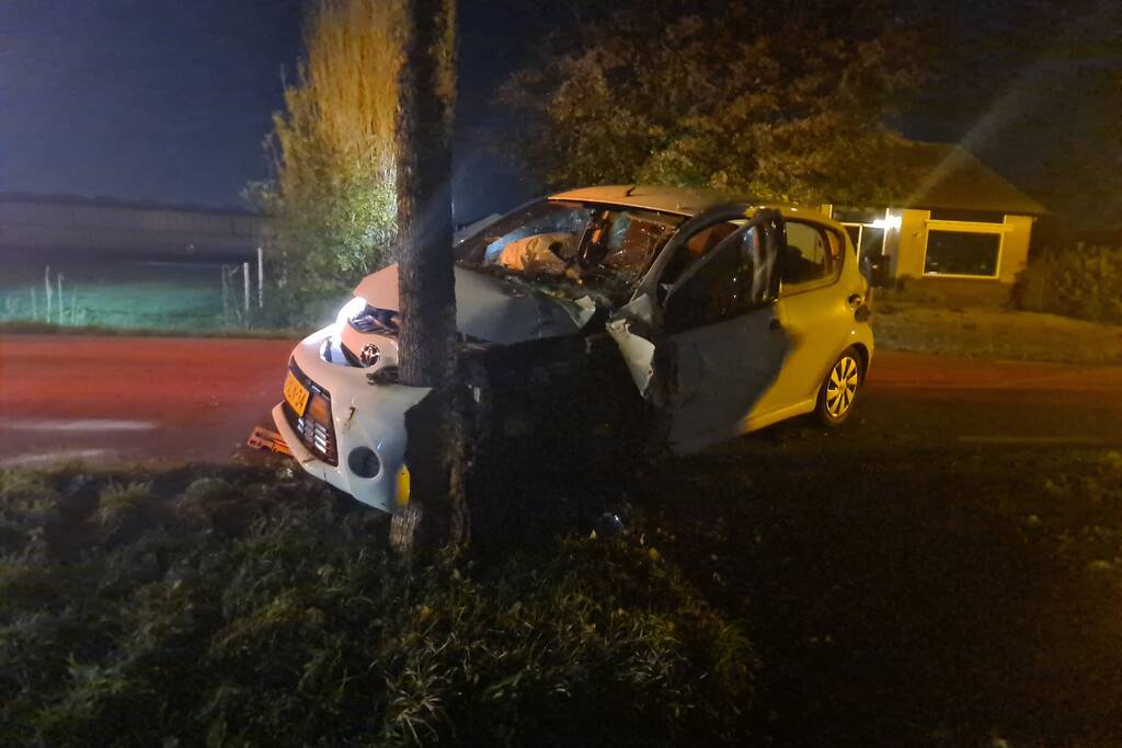 Auto rijdt tegen lantaarnpaal en komt tot stilstand tegen boom