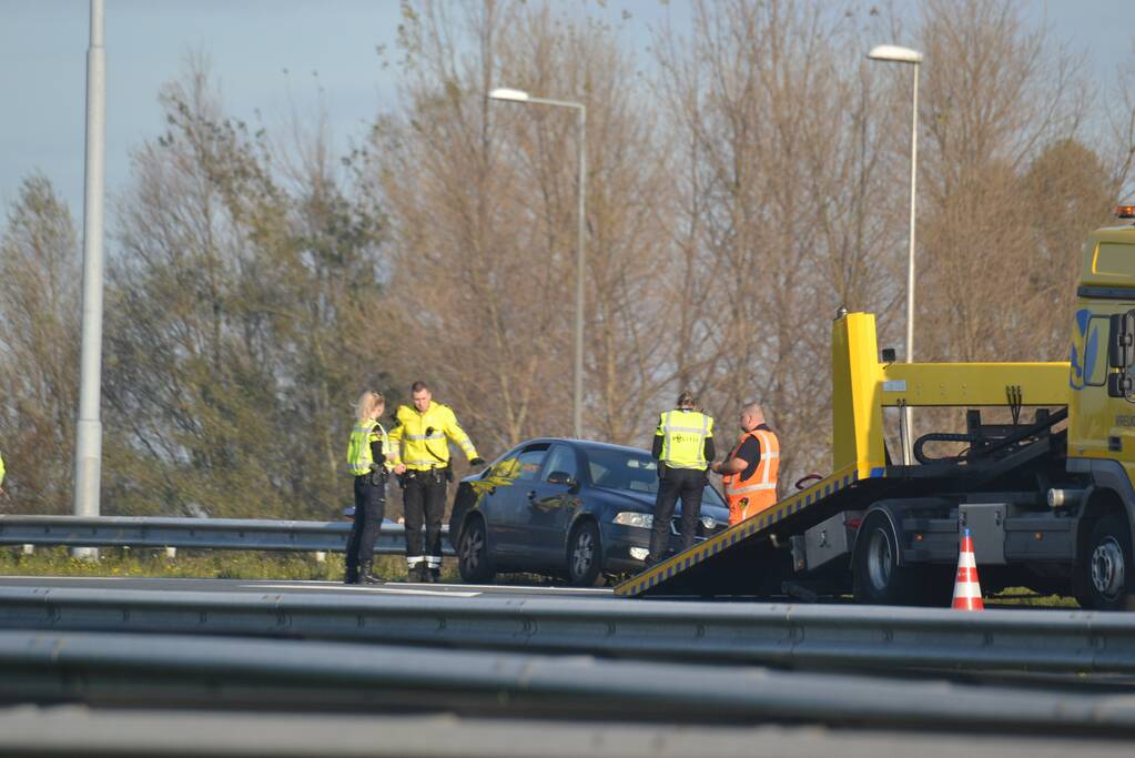 Personenauto heeft schade na botsing tegen vangrail