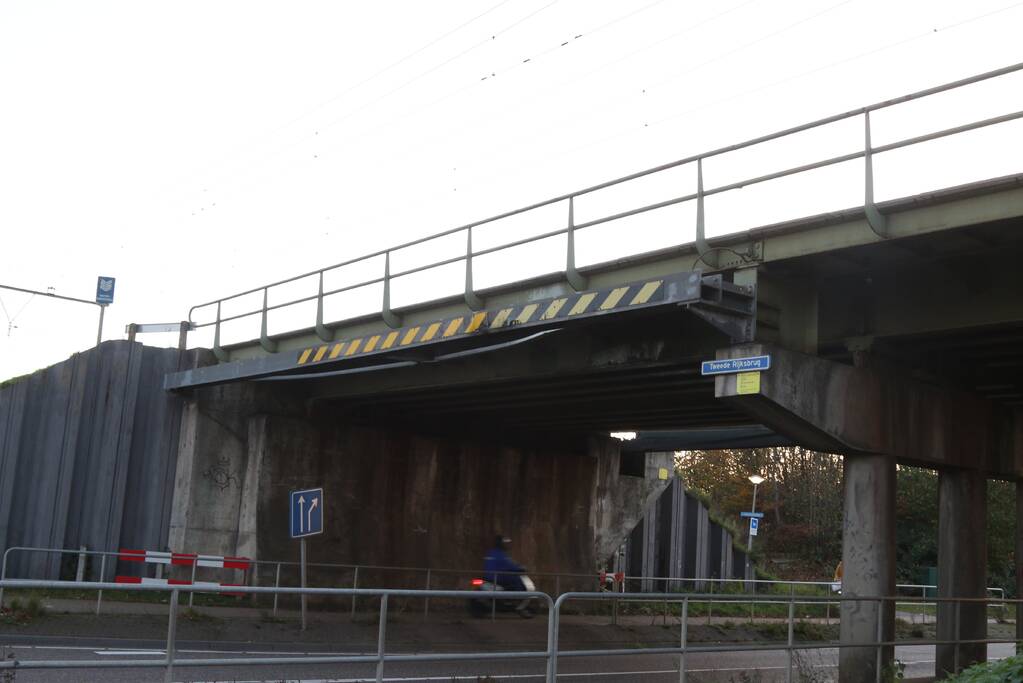 Vrachtwagen met graafmachine ramt spoorbrug