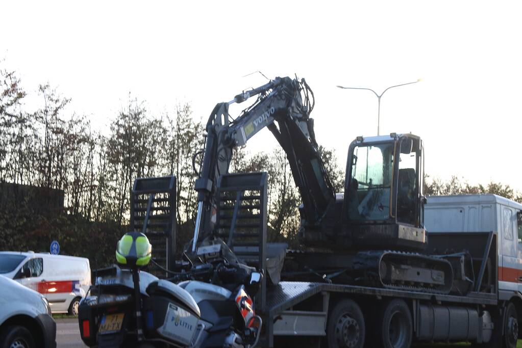 Vrachtwagen met graafmachine ramt spoorbrug