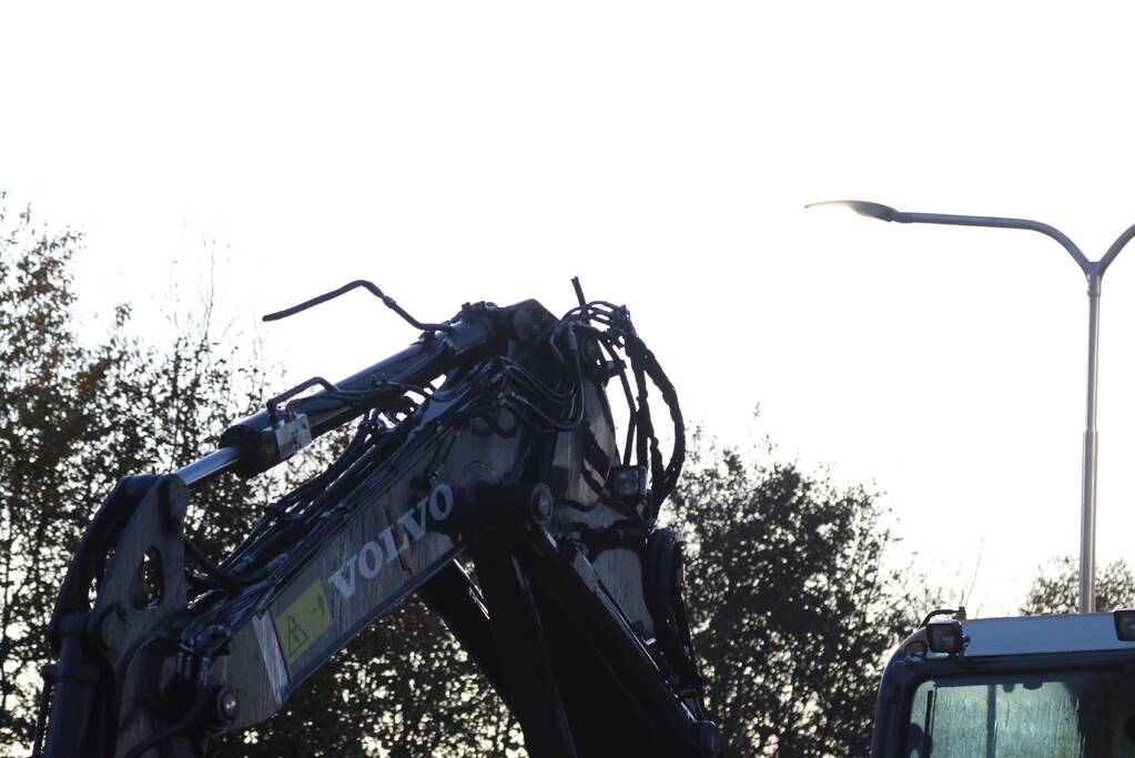 Vrachtwagen met graafmachine ramt spoorbrug