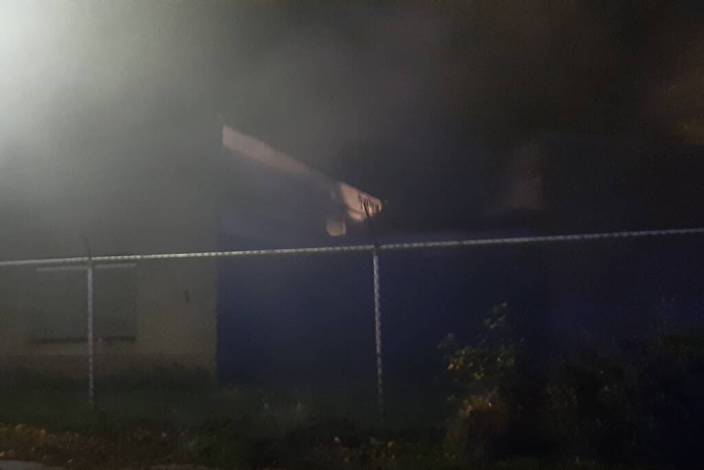 Berg afval in brand achter schoolgebouw