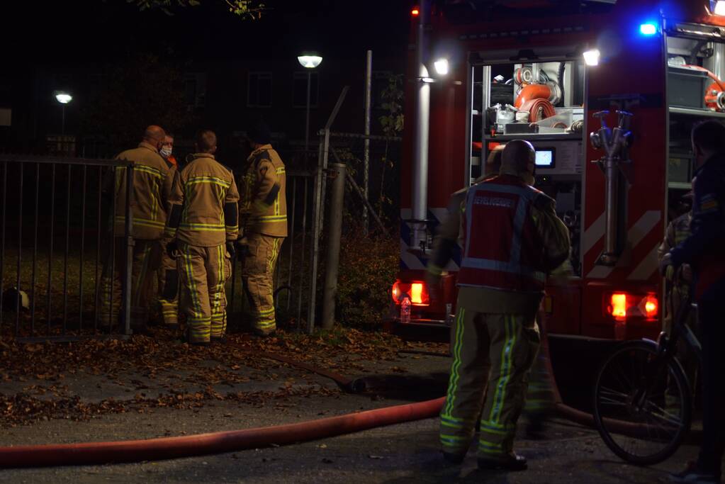 Berg afval in brand achter schoolgebouw