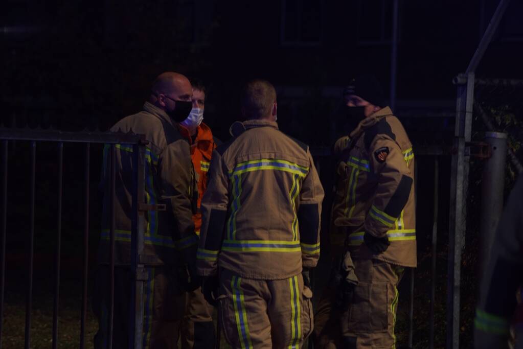 Berg afval in brand achter schoolgebouw