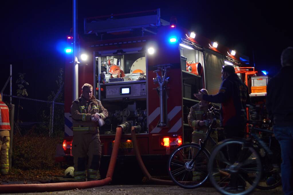 Berg afval in brand achter schoolgebouw