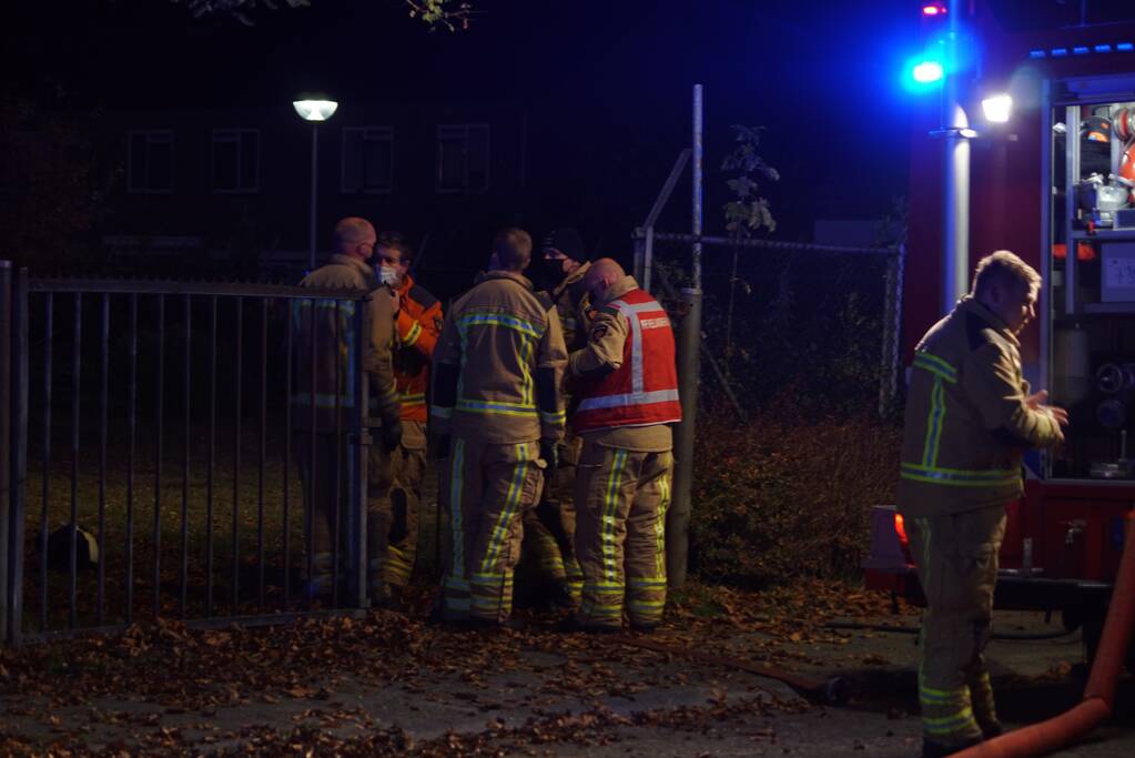 Berg afval in brand achter schoolgebouw