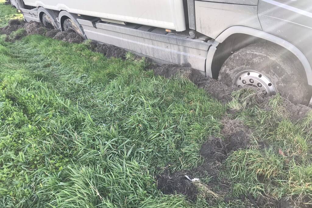 Vrachtwagen rijdt zich vast in berm langs snelweg