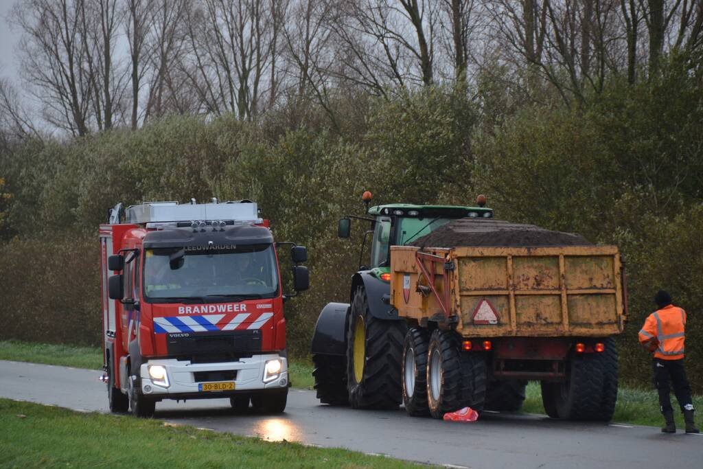 Tractor met lading zand vat vlam