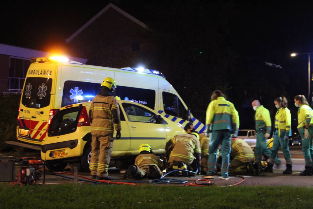 Fietser bekneld onder auto