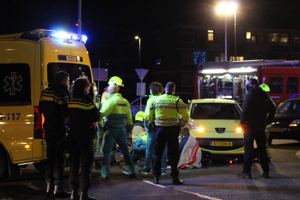 Fietser bekneld onder auto