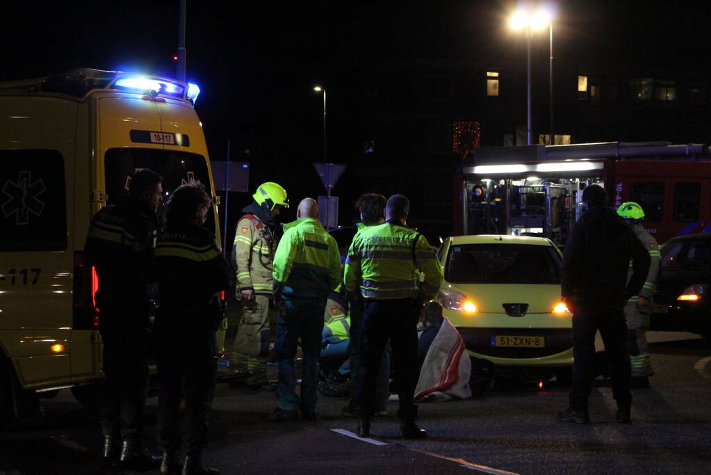 Fietser bekneld onder auto