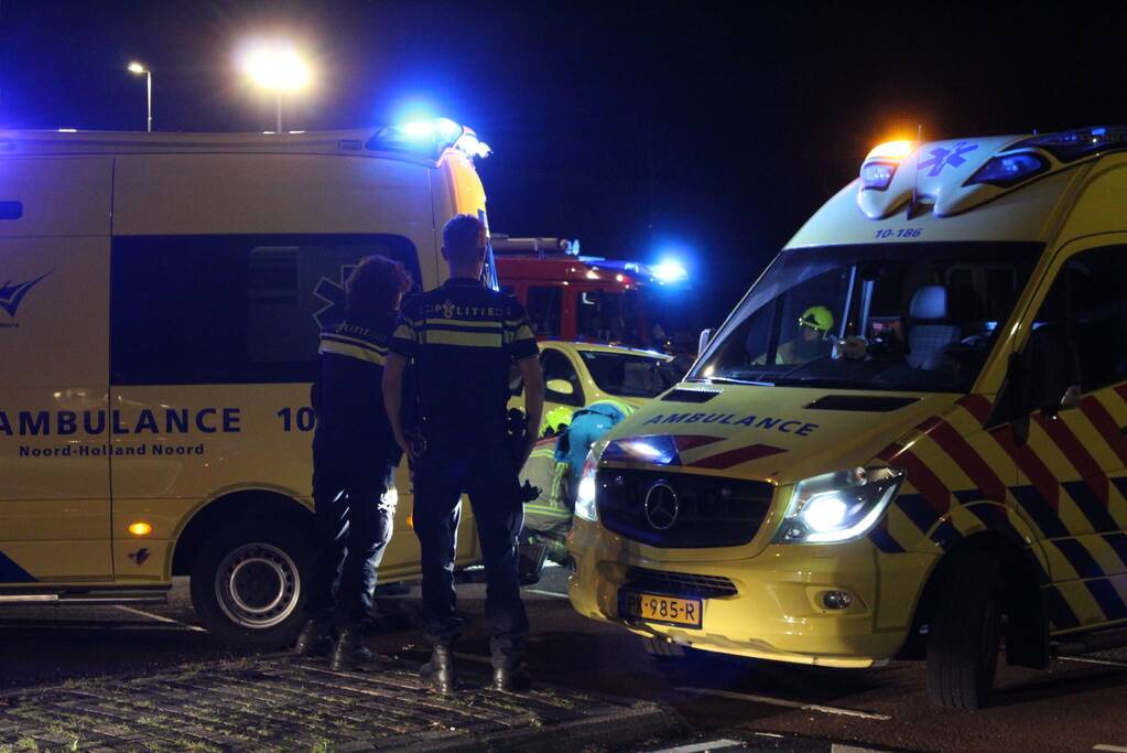 Fietser bekneld onder auto