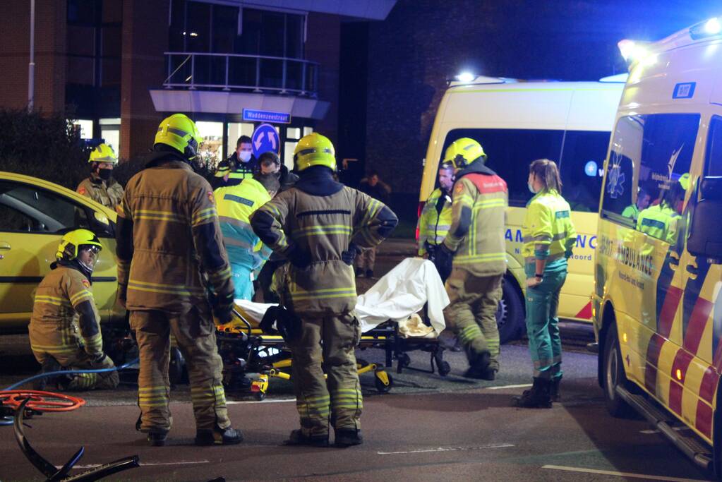 Fietser bekneld onder auto