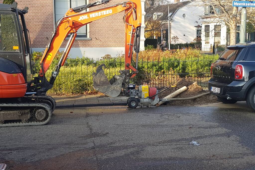 Straat opengebroken door gesprongen waterleiding