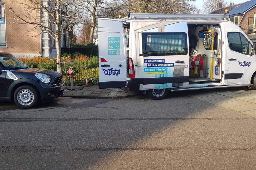 Straat opengebroken door gesprongen waterleiding