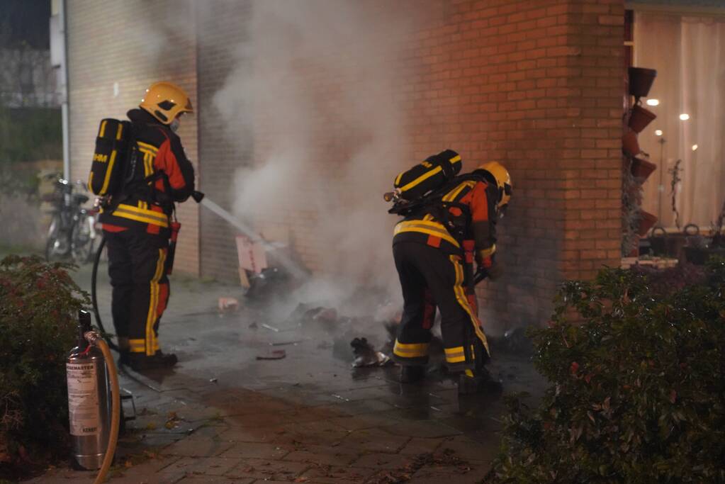 Oud papier tegen woning in brand gestoken