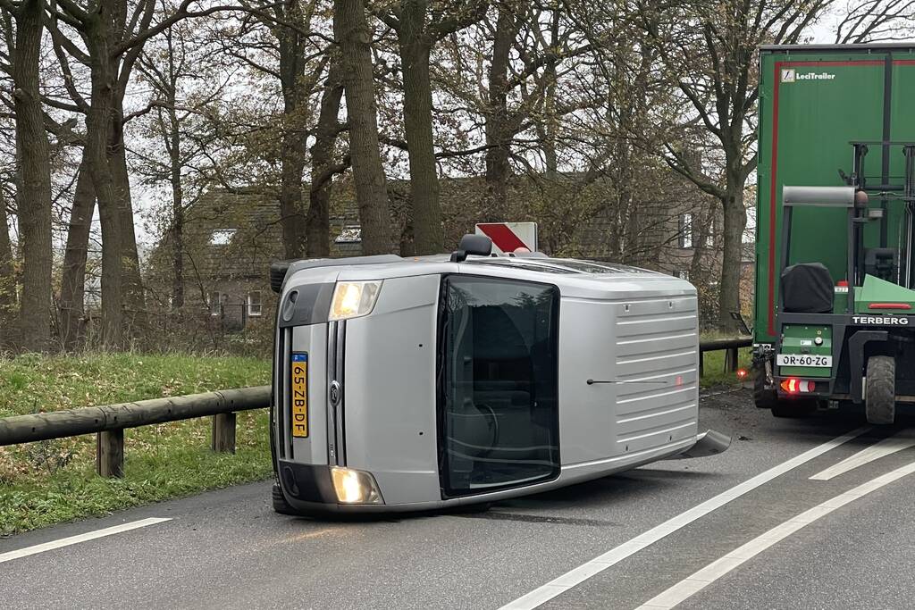 Bestelbus belandt op zijn kant via vangrail