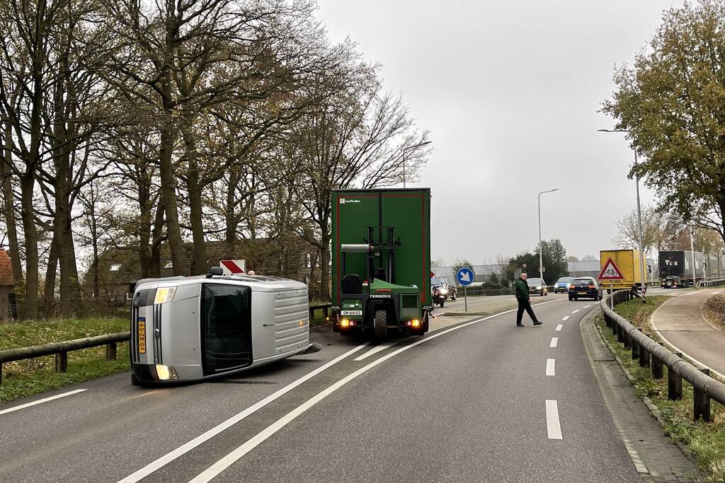 Bestelbus belandt op zijn kant via vangrail