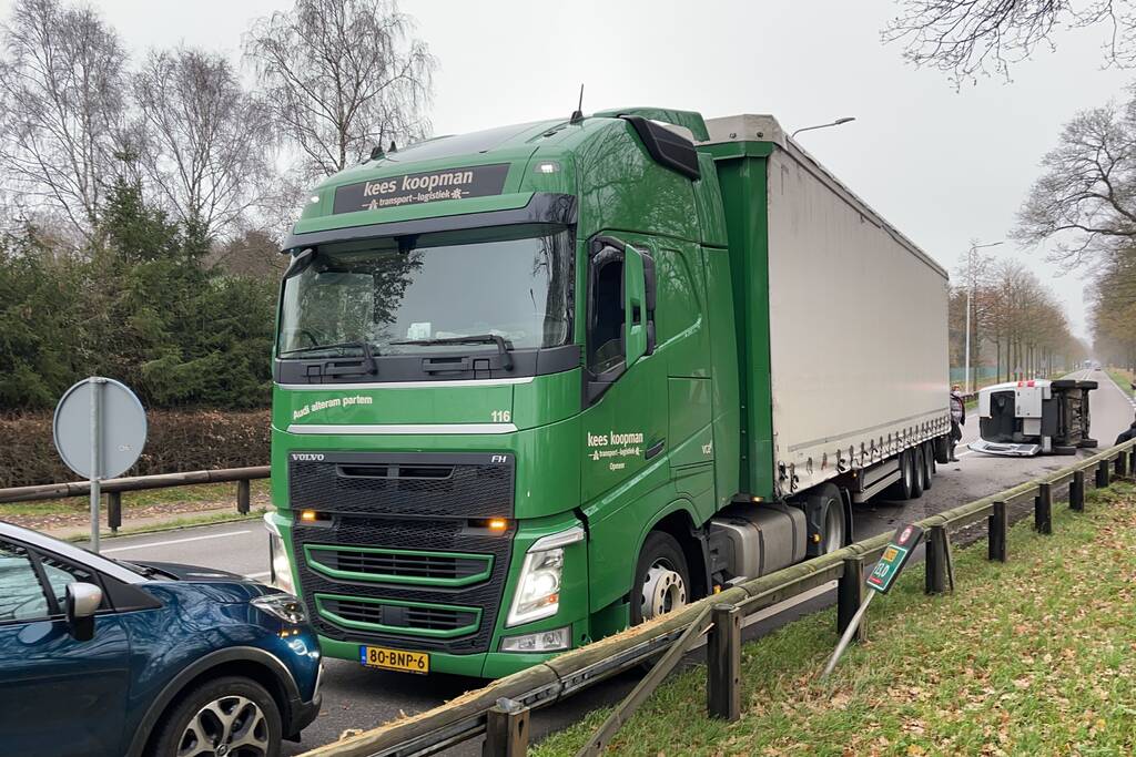 Bestelbus belandt op zijn kant via vangrail