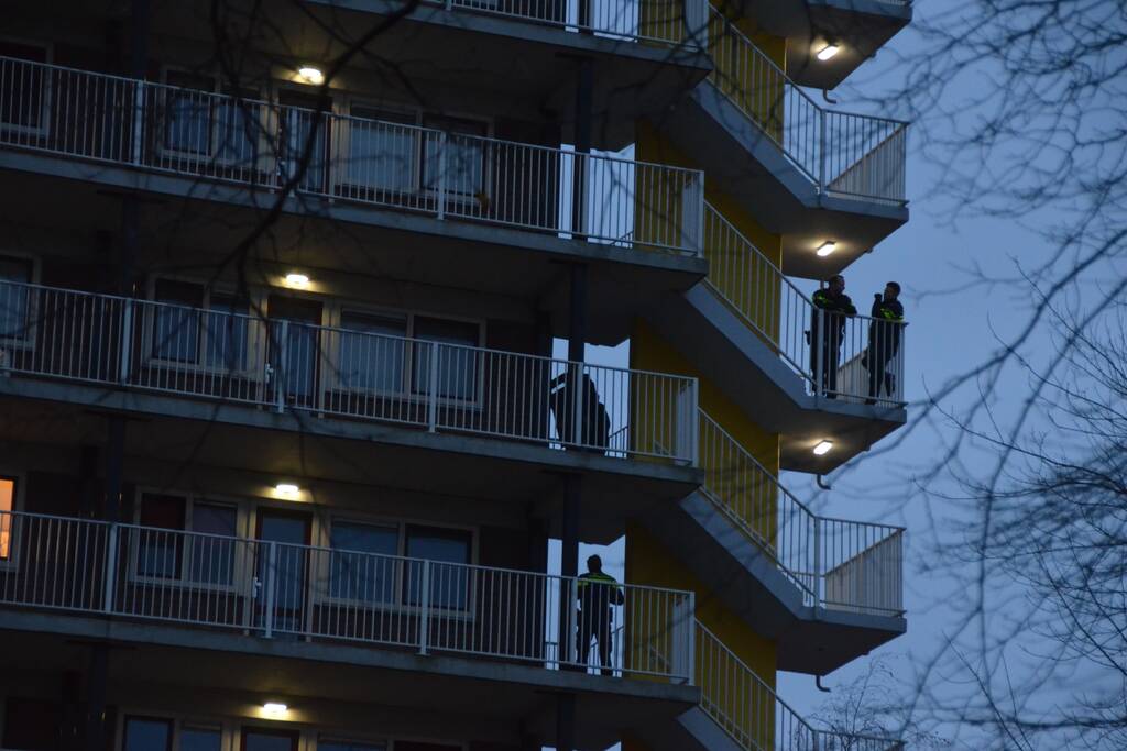 Verward persoon op galerij van flatwoning