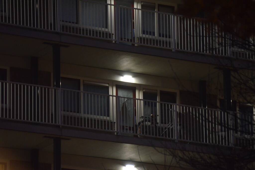 Verward persoon op galerij van flatwoning