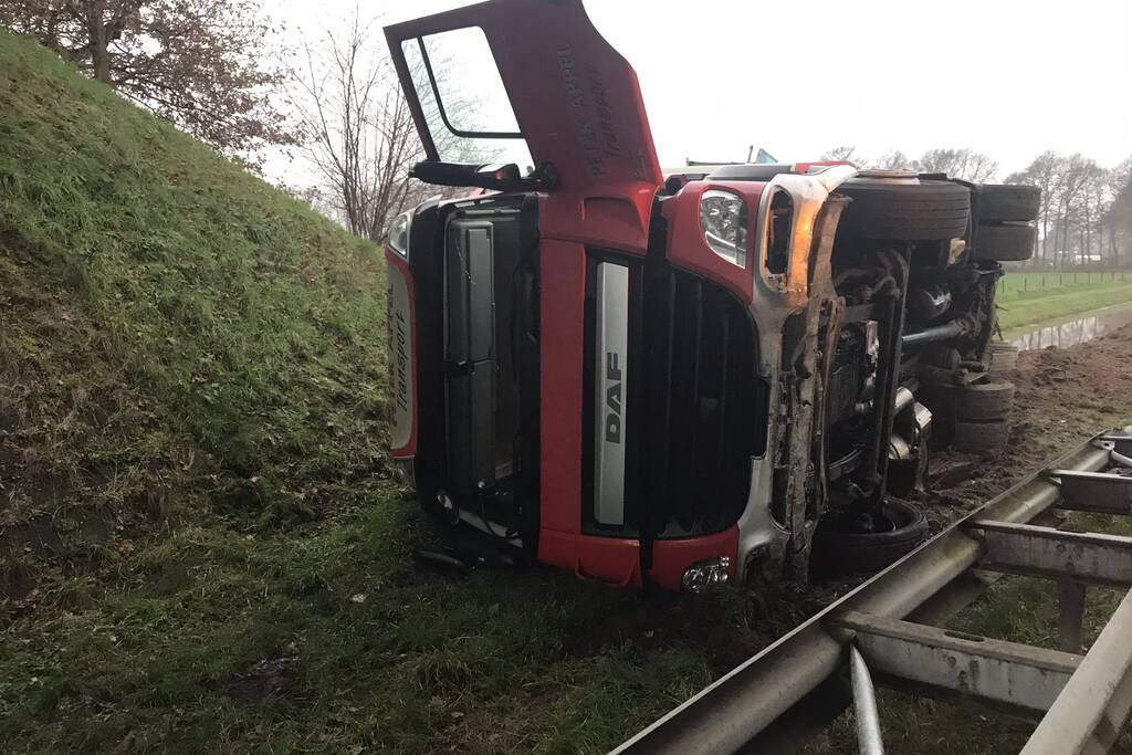 Vrachtwagen belandt op zijn kant in de berm