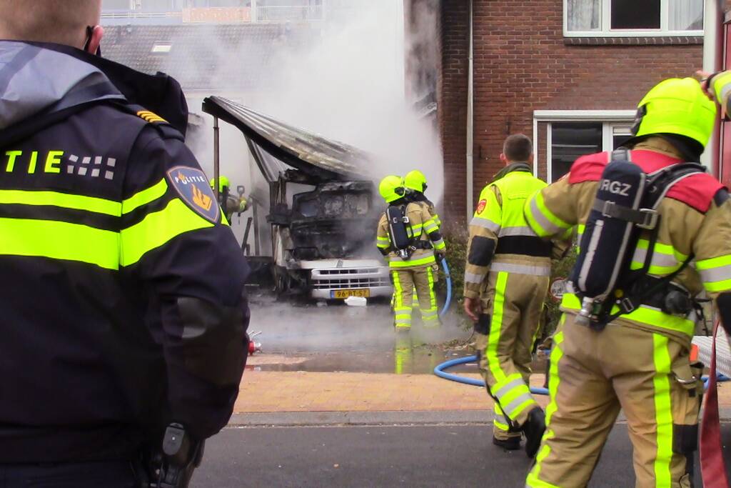 Camper naast woning gaat in vlammen op