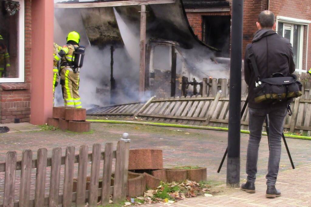 Camper naast woning gaat in vlammen op