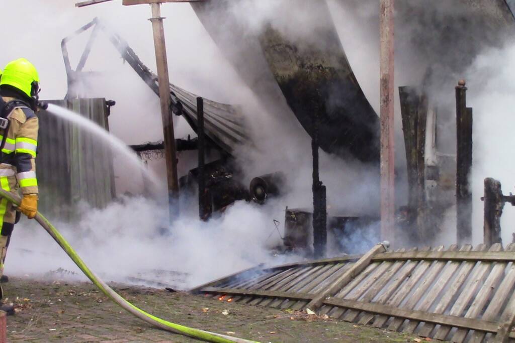 Camper naast woning gaat in vlammen op