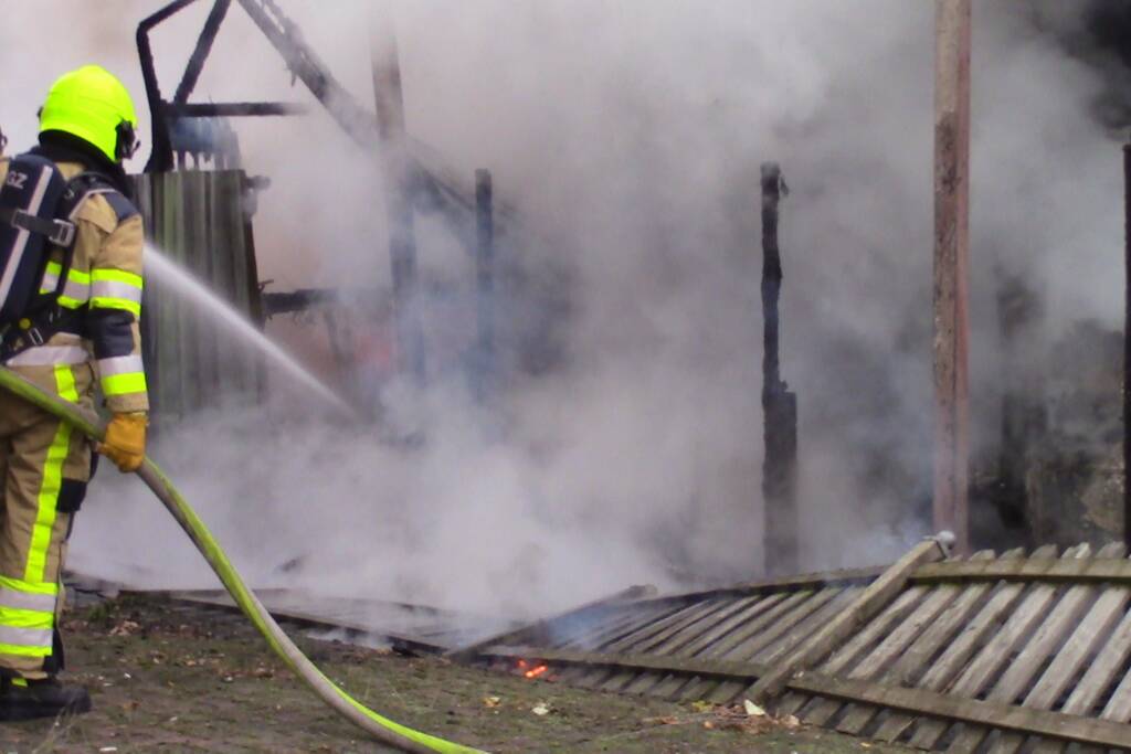 Camper naast woning gaat in vlammen op