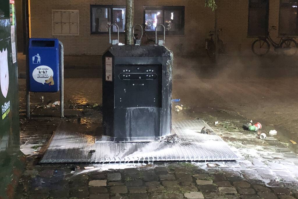 Papier in brand naast container