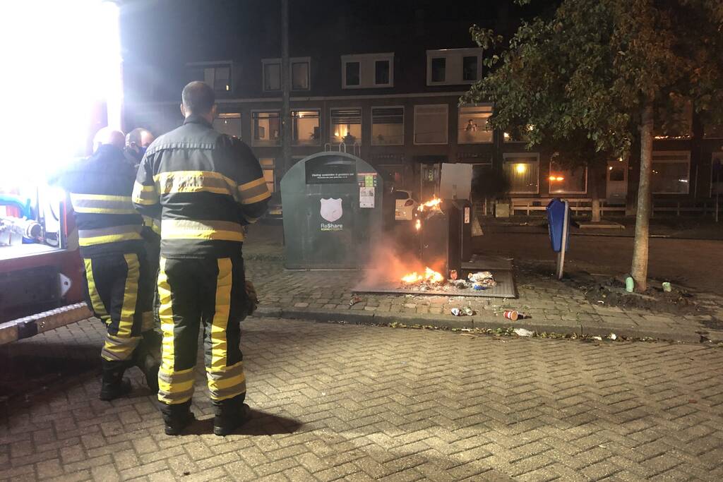 Papier in brand naast container