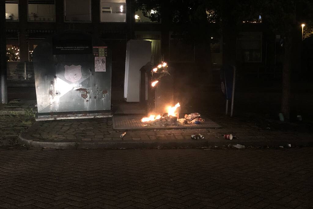 Papier in brand naast container