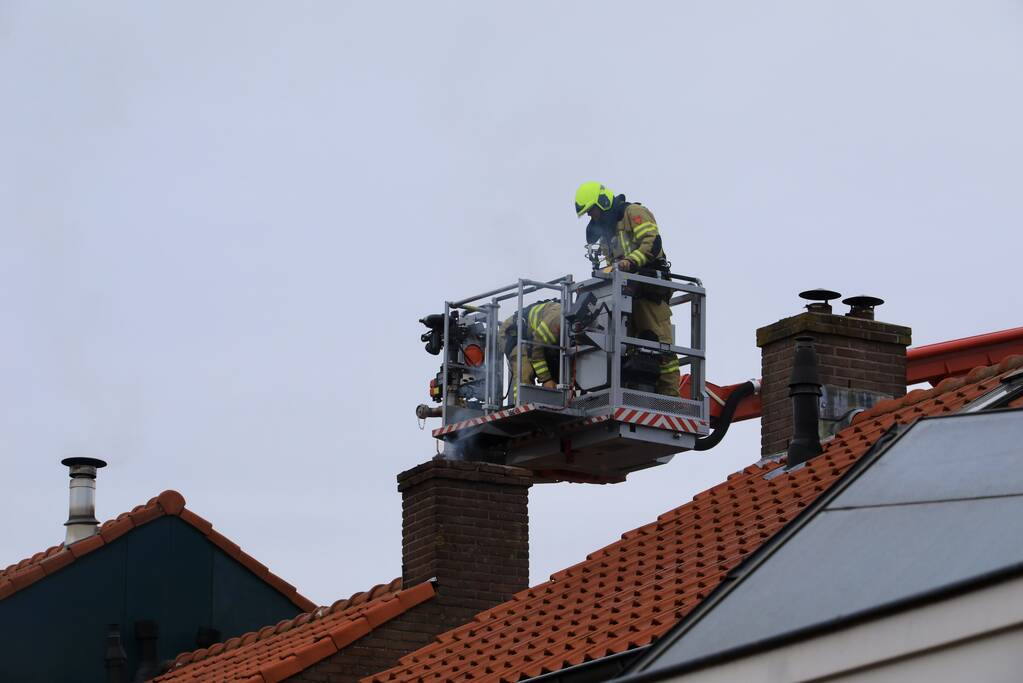 Brandweer blust brand in schoorsteen