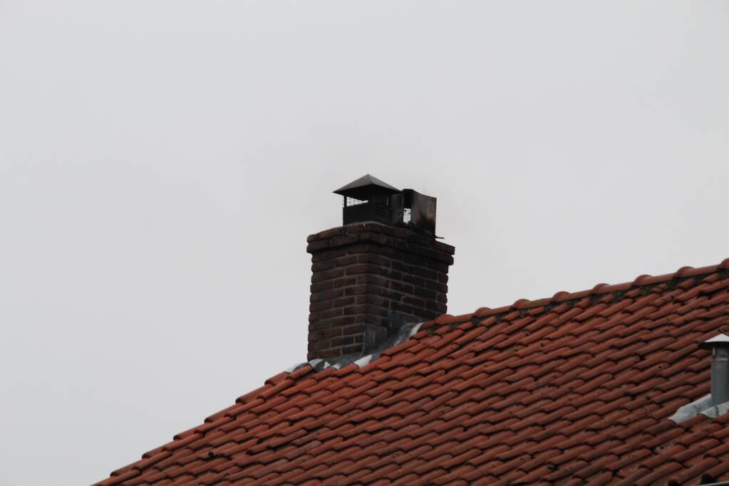 Brandweer blust brand in schoorsteen