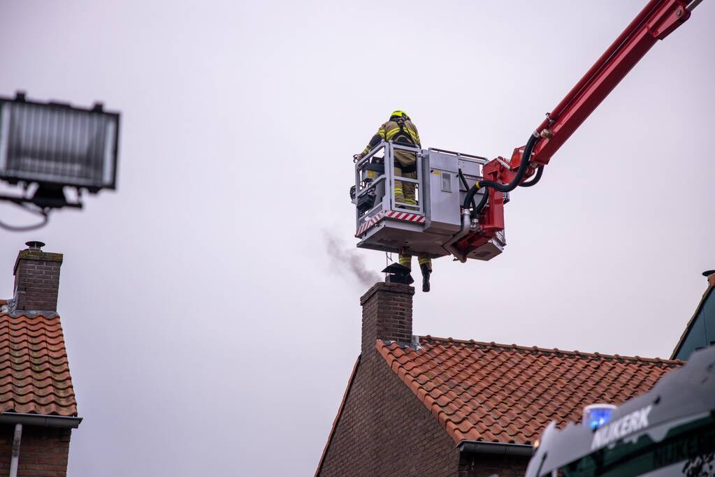 Brandweer blust brand in schoorsteen