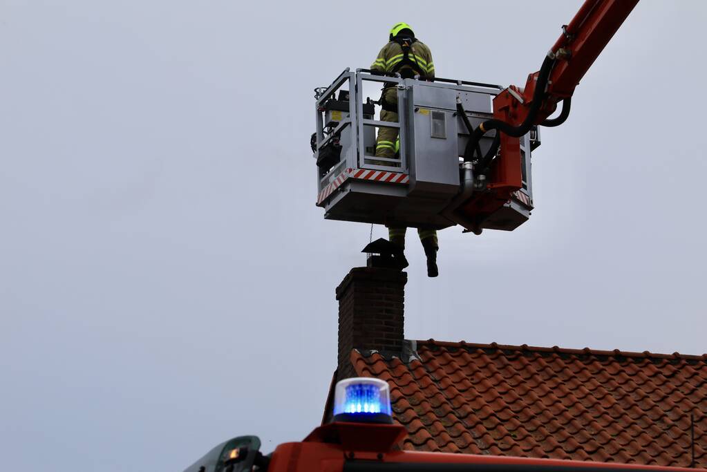 Brandweer blust brand in schoorsteen