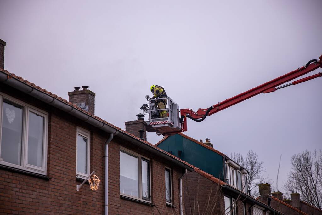 Brandweer blust brand in schoorsteen