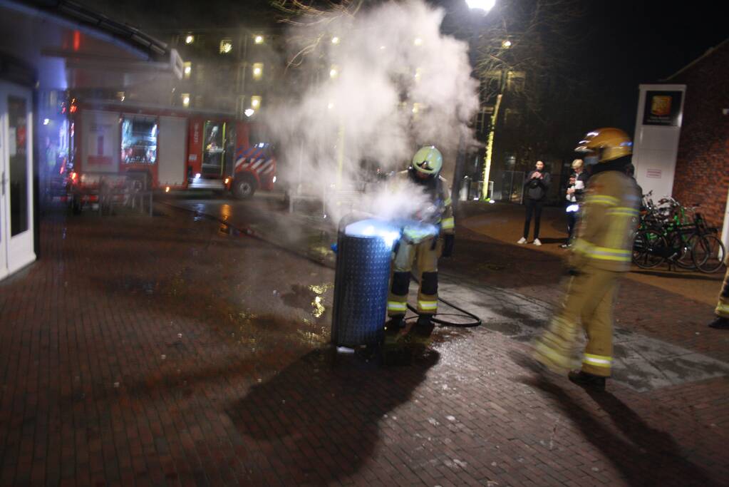 Brandweer blust twee brandende prullenbakken
