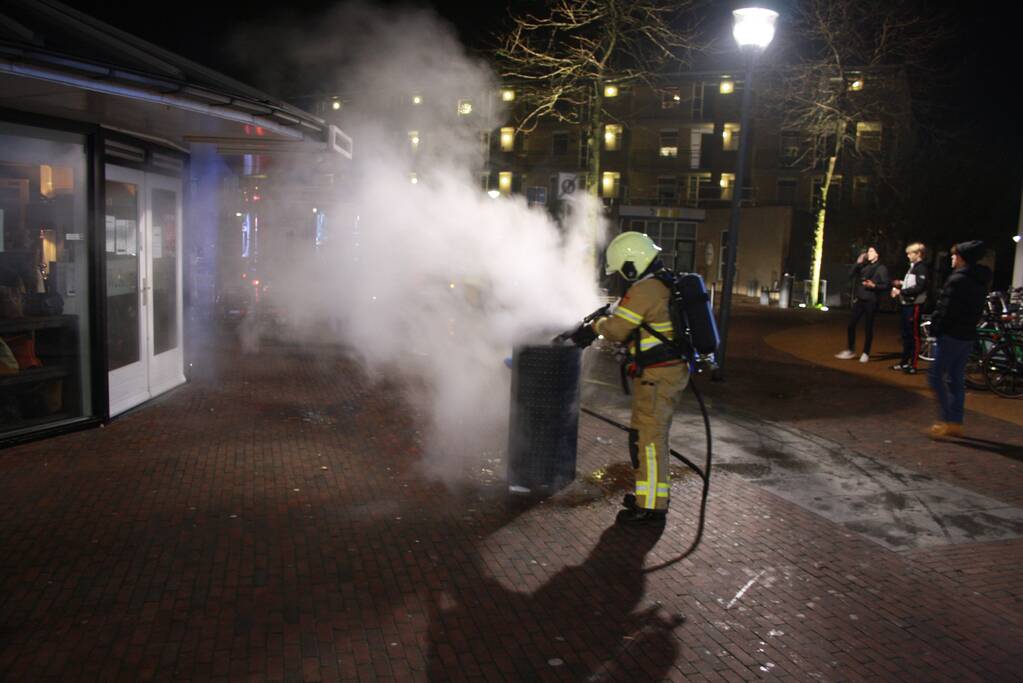 Brandweer blust twee brandende prullenbakken