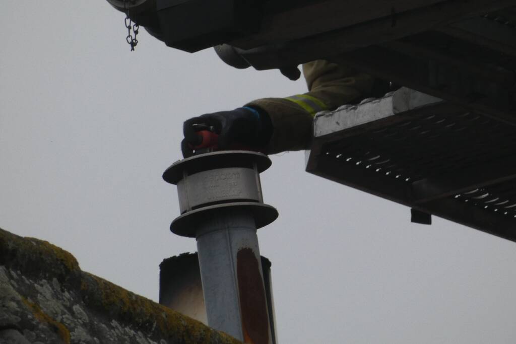 Brandweer blust brand in schoorsteen