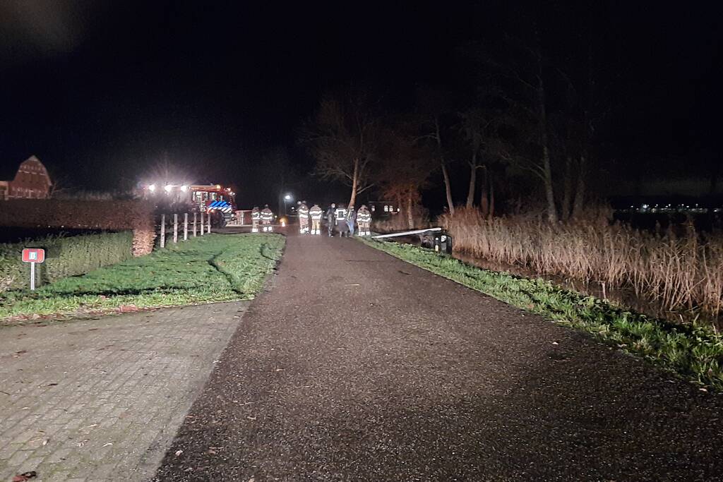 Auto vliegt uit de bocht en belandt op zijn kant in sloot