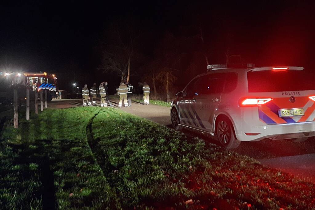 Auto vliegt uit de bocht en belandt op zijn kant in sloot