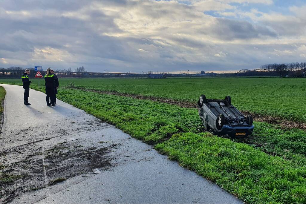 Personenauto raakt van de weg en belandt op zijn dak
