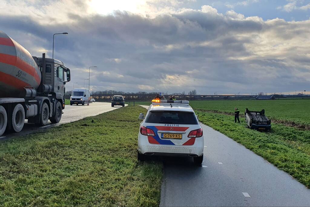 Personenauto raakt van de weg en belandt op zijn dak