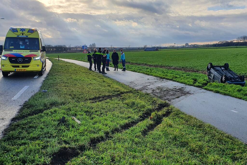 Personenauto raakt van de weg en belandt op zijn dak