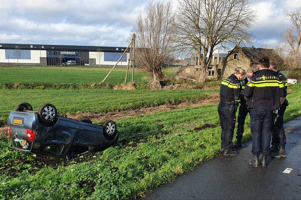 Personenauto raakt van de weg en belandt op zijn dak