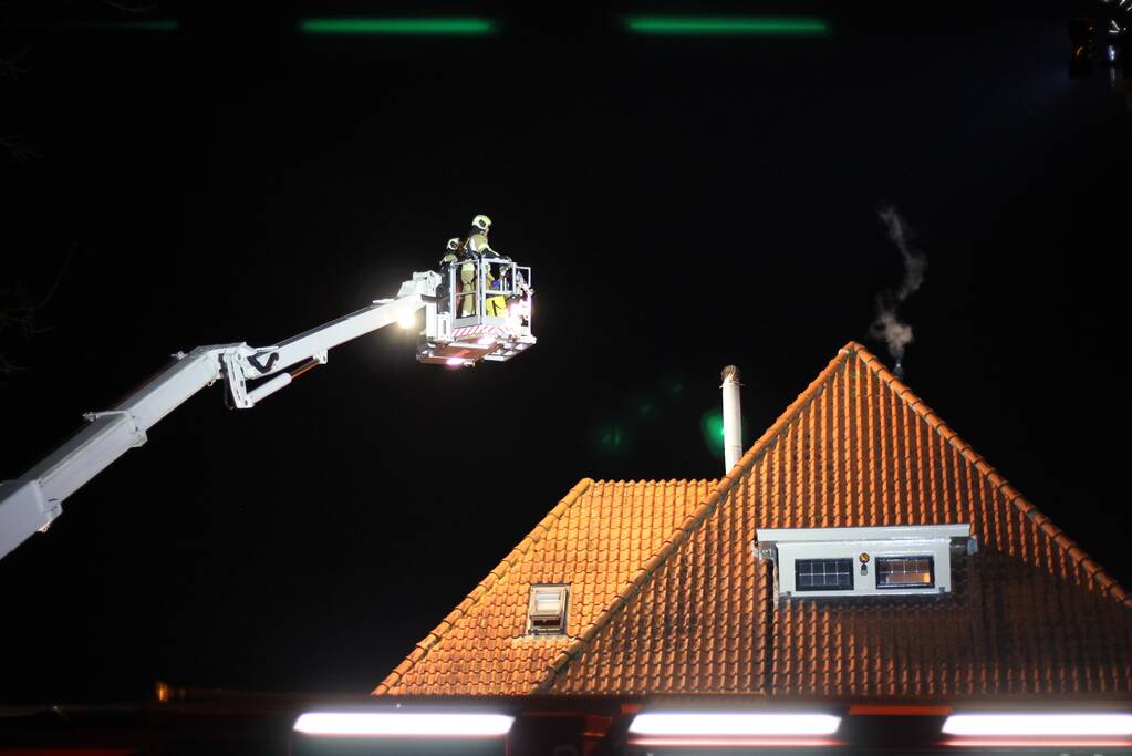 Brandweer blust brand in schoorsteen